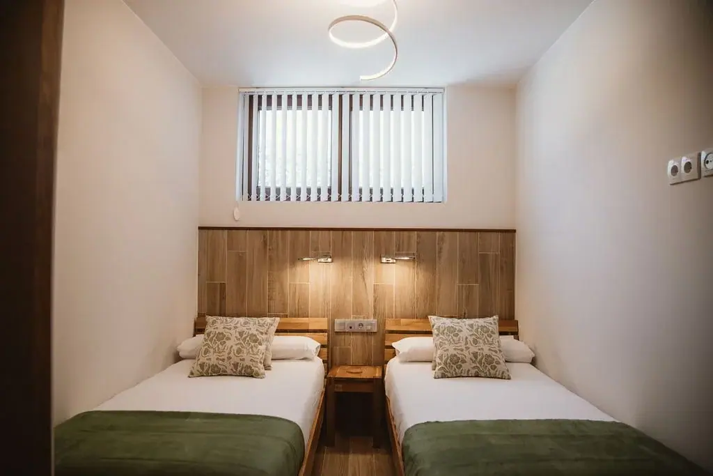Twin bedroom with reading lamps in a Standard apartment