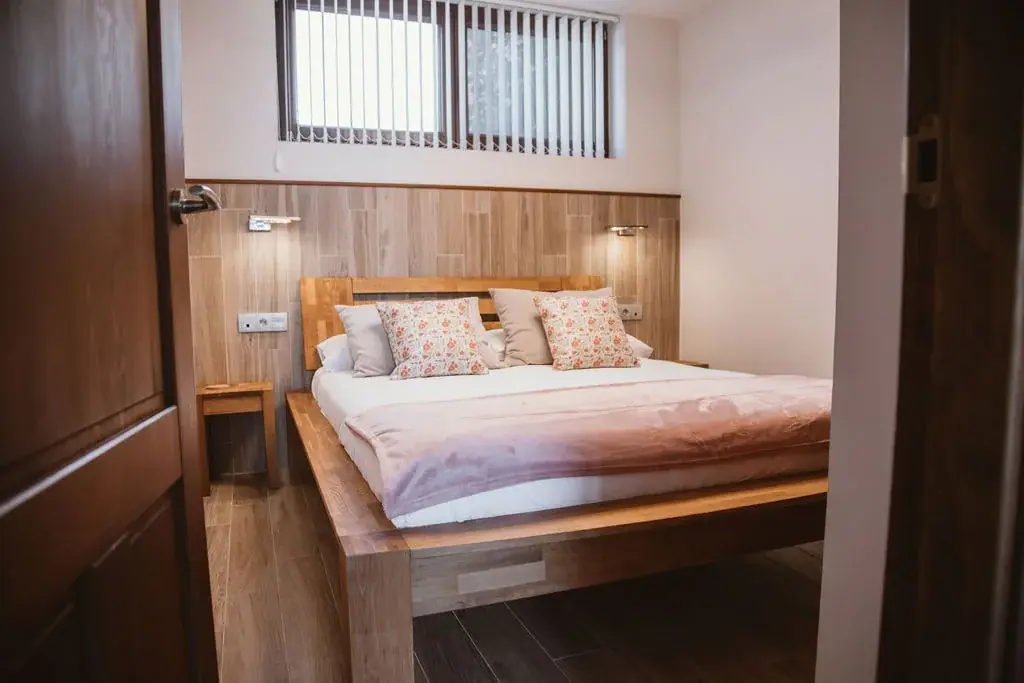 Double bedroom with a wooden headboard in a Standard apartment