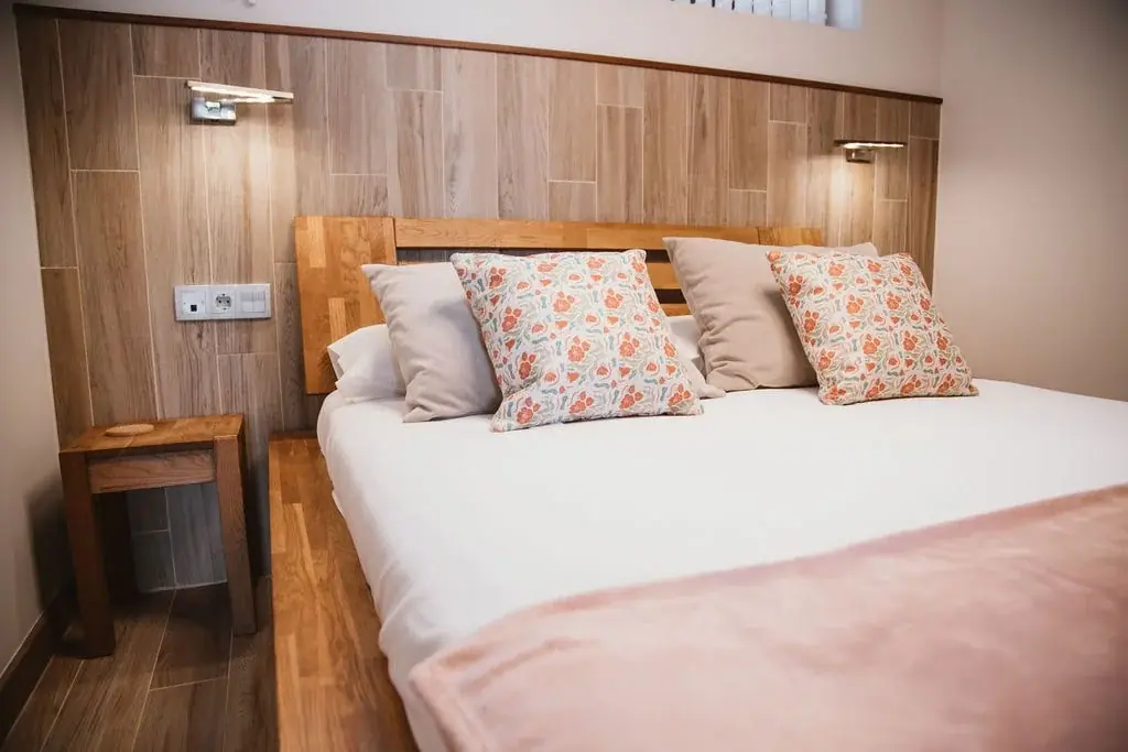 Double bed with a wooden headboard in a Standard apartment