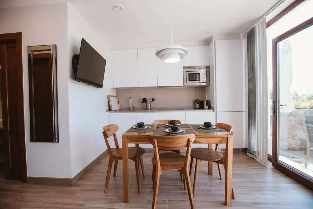 Kitchen and dining area of a Standard apartment, with a door to the garden