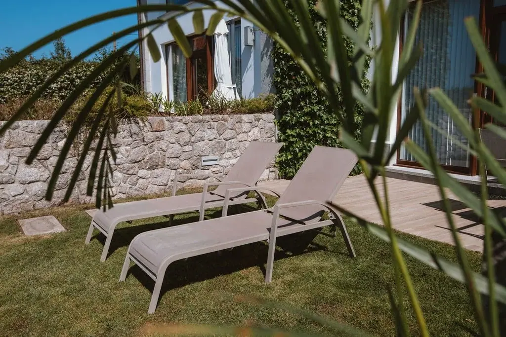 Sun loungers by the stone wall of the garden