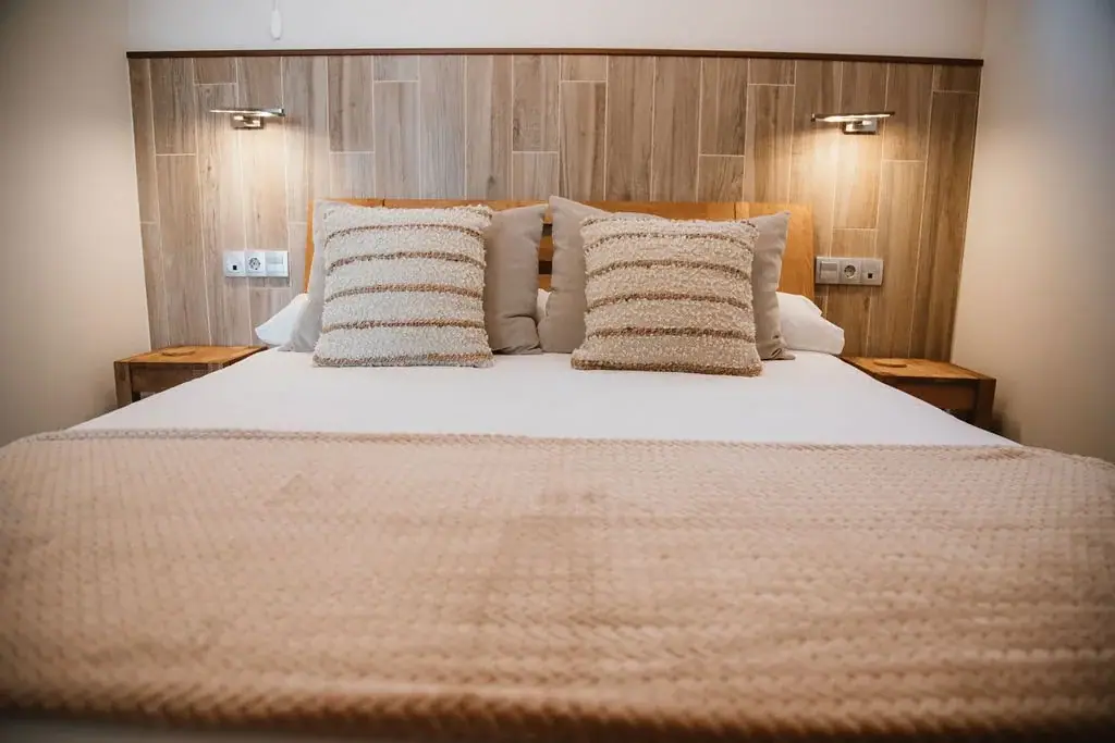 Double bed with cushions and reading lamps in a Standard apartment