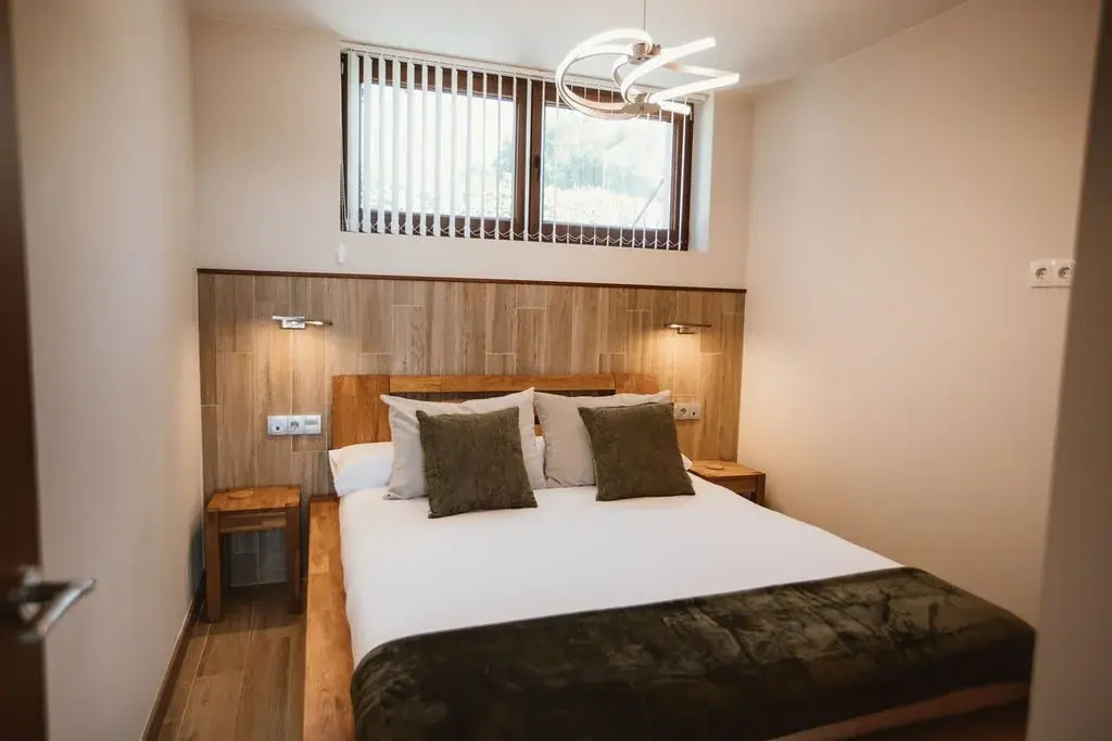 Double bedroom with a green throw in a Standard apartment