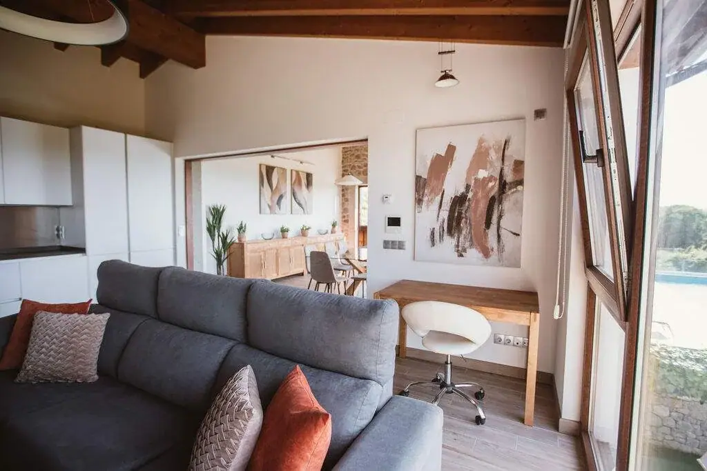 Salón del apartamento Deluxe con sofá gris y zona de trabajo junto a la ventana