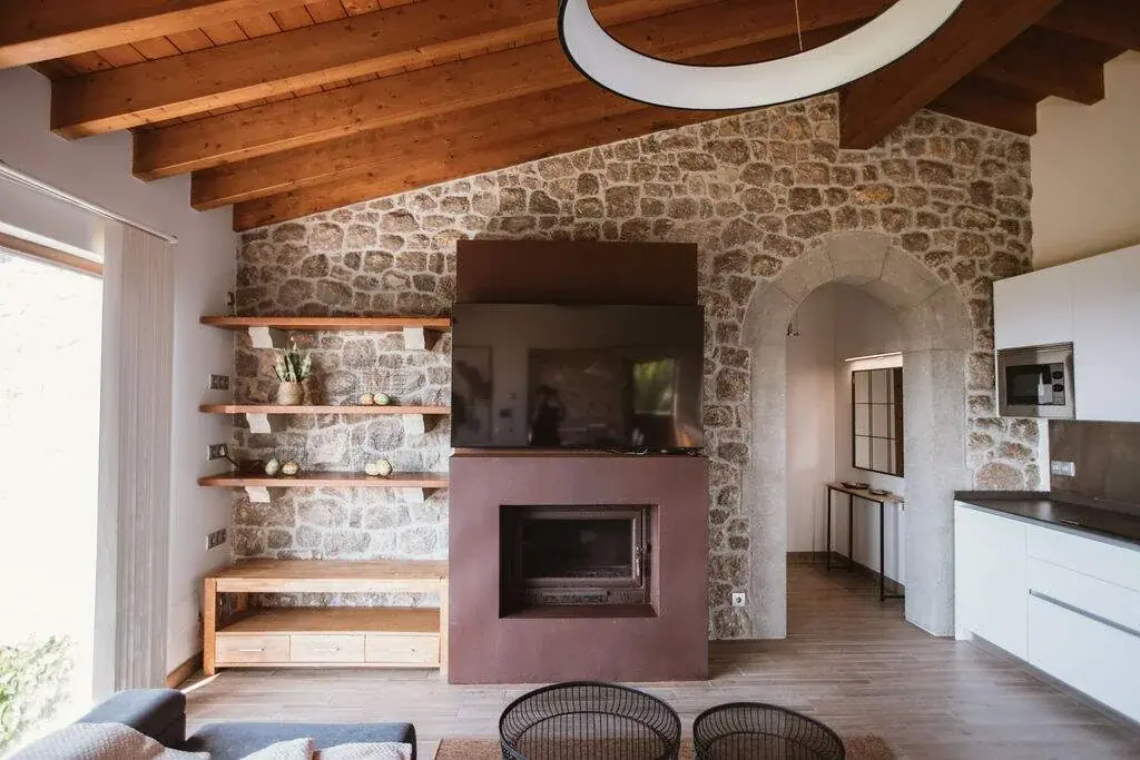 Kitchen of the Deluxe apartment with a fireplace and a stone wall