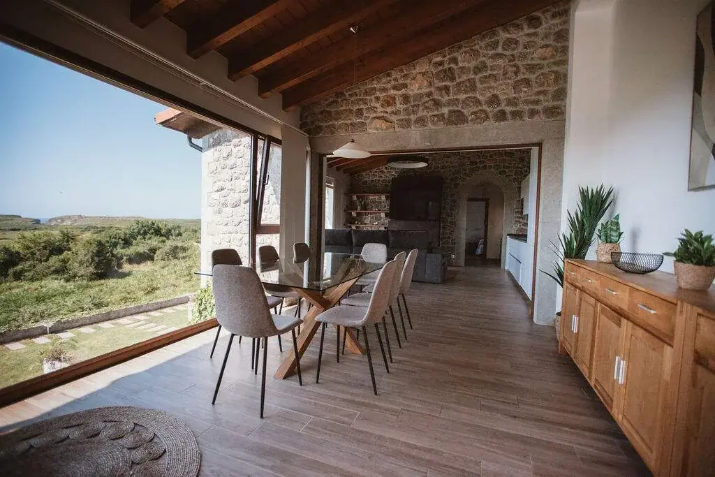 Dining room of the Deluxe apartment with a stone wall and wooden beams