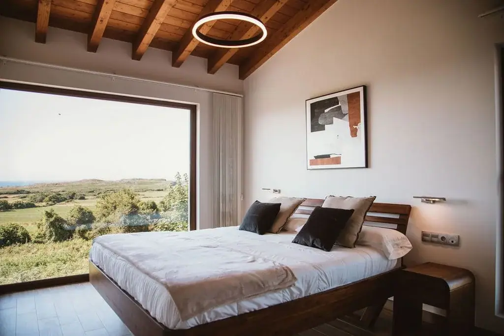 Bedroom of the Deluxe apartment with a wooden ceiling and a picture window