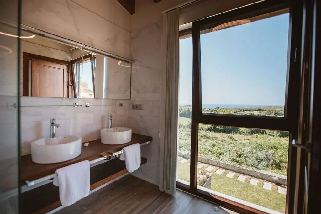 Bathroom of the Deluxe apartment with two washbasins and a window onto the garden
