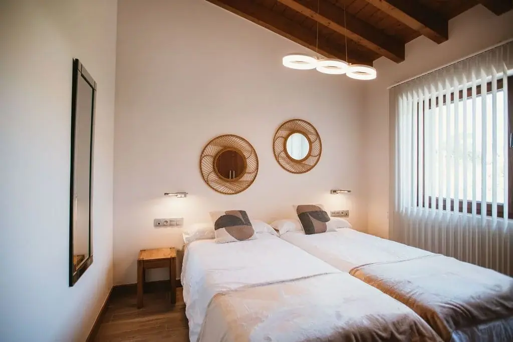 Twin bedroom of the Deluxe apartment, with round mirrors