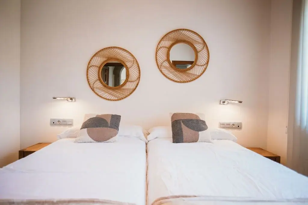 Twin bedroom of the Deluxe apartment with wicker mirrors
