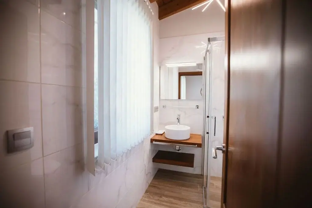 Bathroom of the Deluxe apartment with a washbasin on a wooden counter
