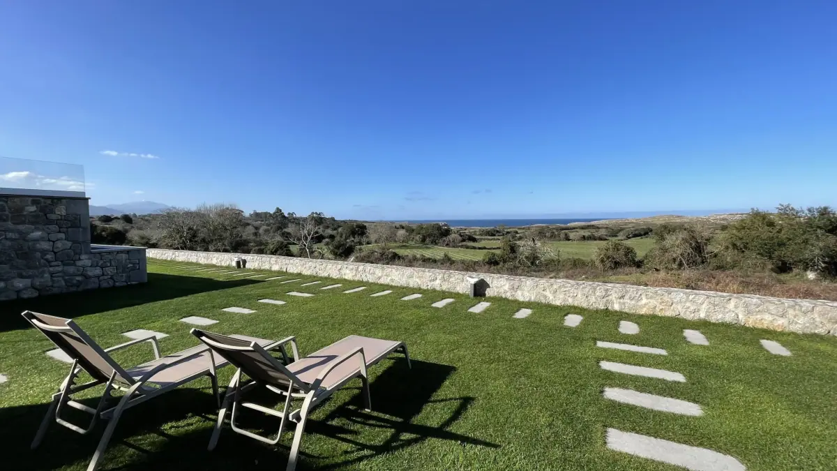 Sun loungers in the garden with the sea beyond