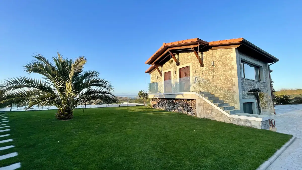 The stone house with its palm tree and garden lawn