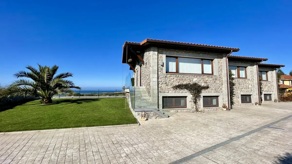 The stone building of the Bufones de Pría apartments with its cobbled drive