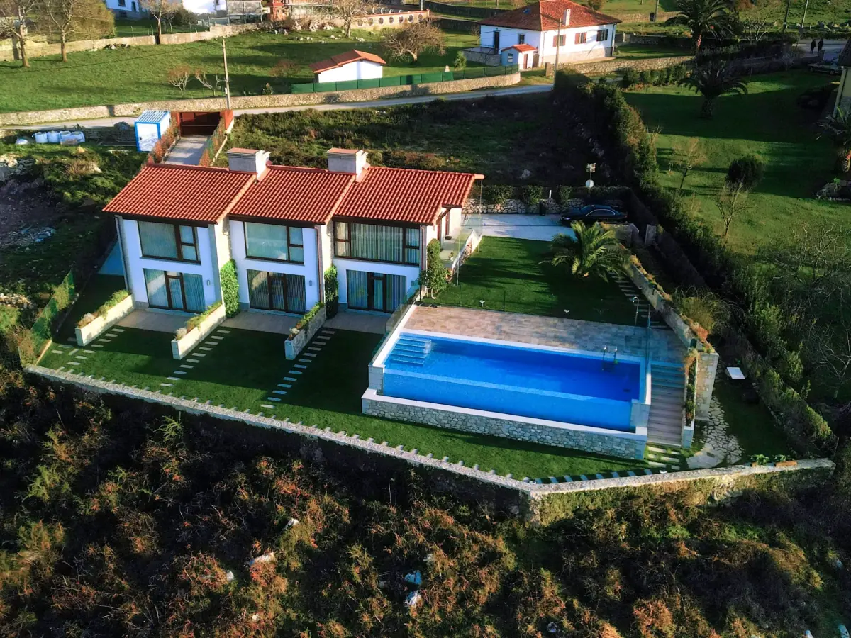 Aerial view of the Bufones de Pría apartments and their infinity pool among the meadows
