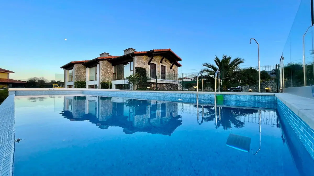 Infinity pool with the stone house reflected in the water