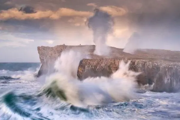 A storm swell against the cliff
