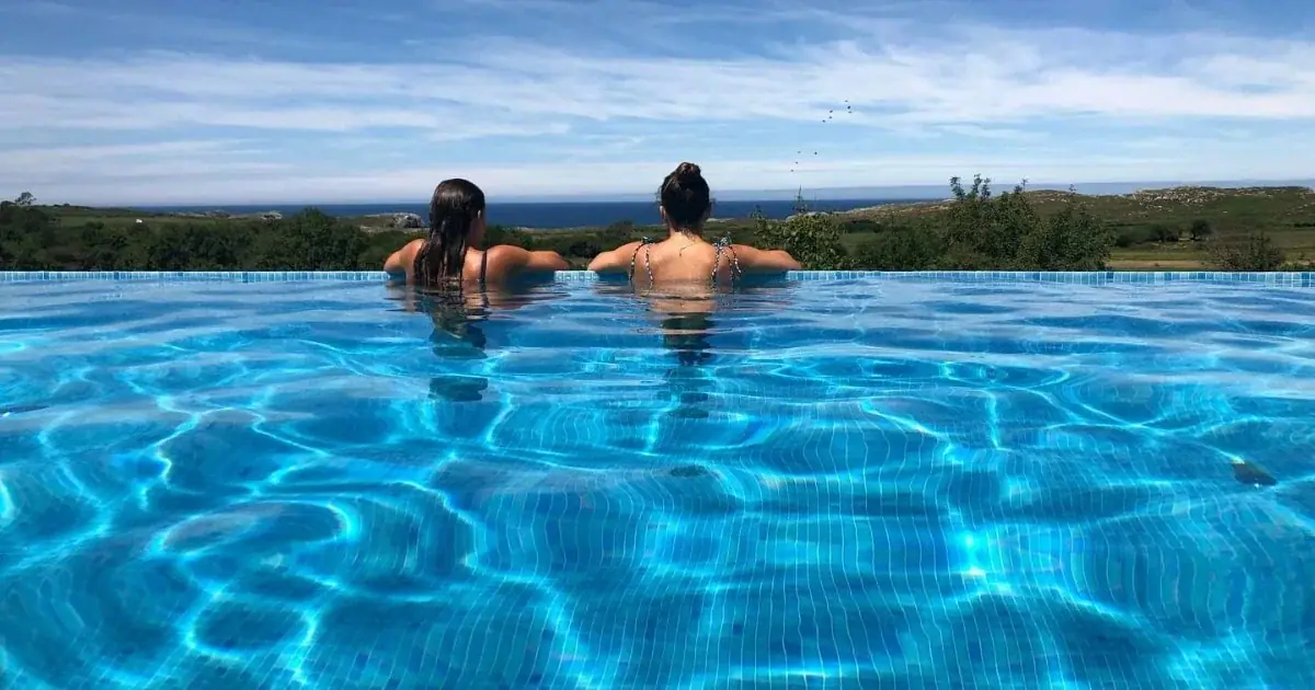 Two people in the infinity pool looking out to sea
