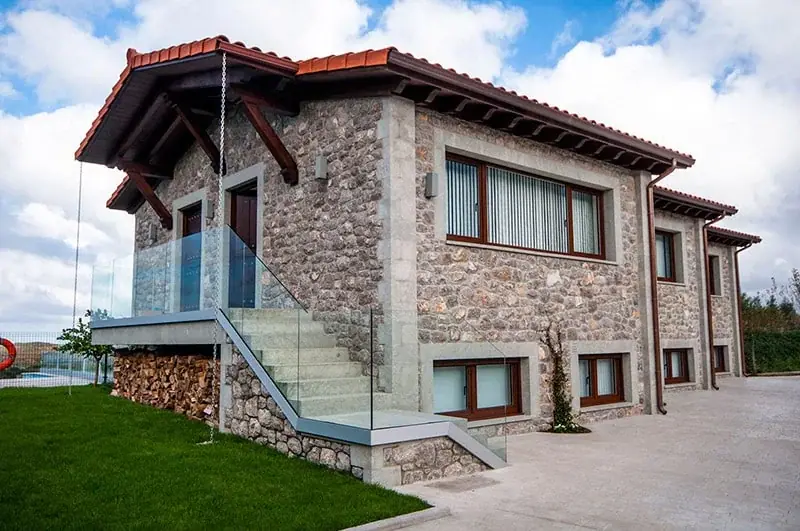 The stone house with its glass outdoor staircase
