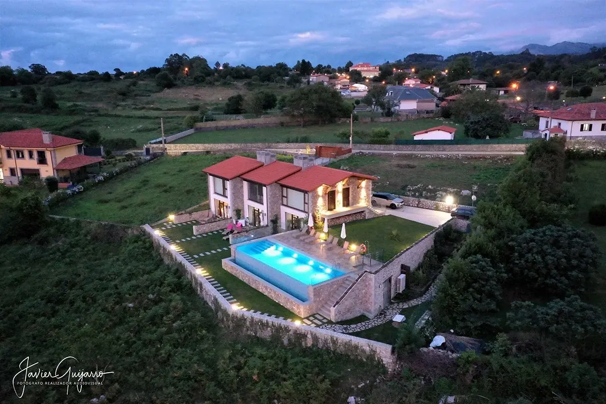 Aerial view of the apartments and the lit pool at dusk