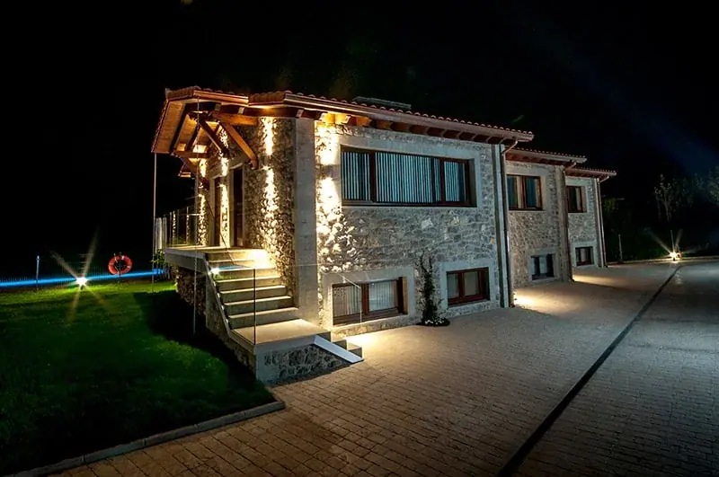 The stone house lit up at night