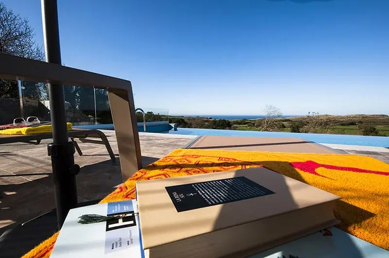 A towel by the edge of the pool, facing the sea