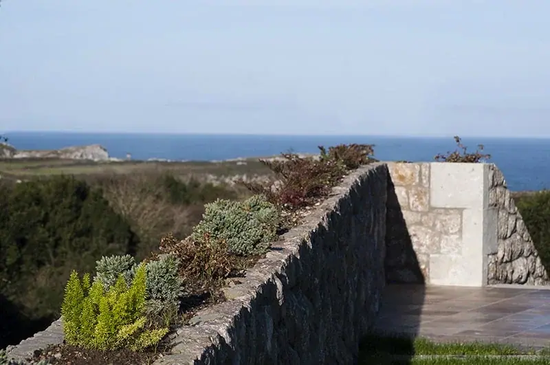 The garden's stone wall with the sea beyond