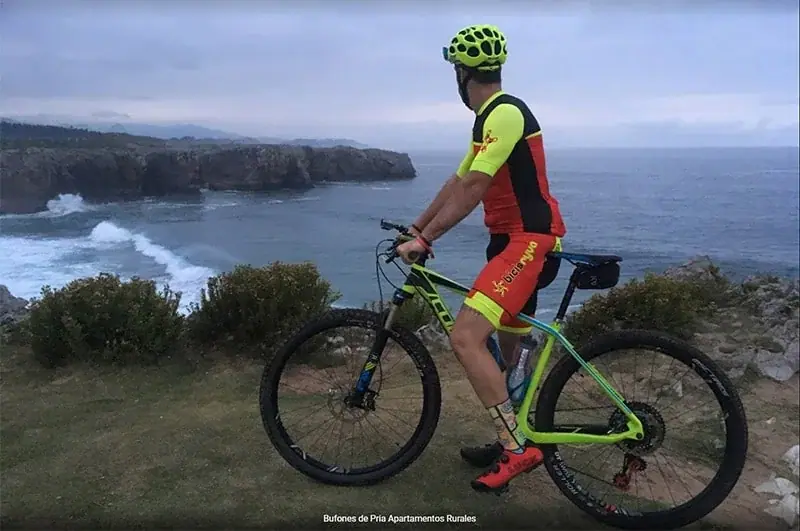 A cyclist on the Bufones trail, beside the cliff